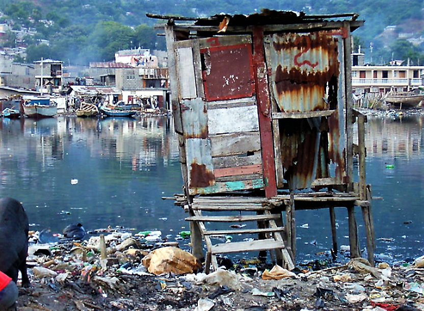 An overhung latrine in Port Haitien (Haiti). It is hard and unsafe to enter, especially for elder people and children. The contamination of the water body is obvious. Source: AIDG on Flickr (2007) 