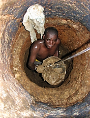 A toilet emptier passes the bucket full of faecal sludge to his assistant. The man works without gloves, boots and mask, because these are too expensive. The health risk in this case is extremely high. Source: SuSanA on Flickr (2010)     